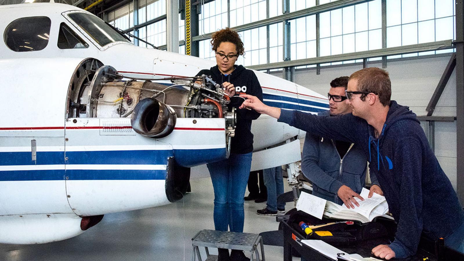 Aircraft maintenance technitians working on an airplane engine
